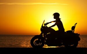 riding a motorcycle past a sunset