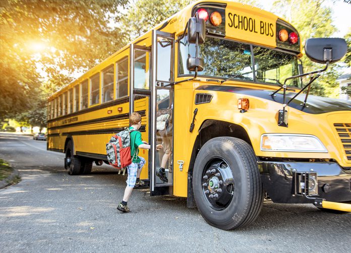 child getting onto a school bus